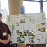 Student stands by poster presentation